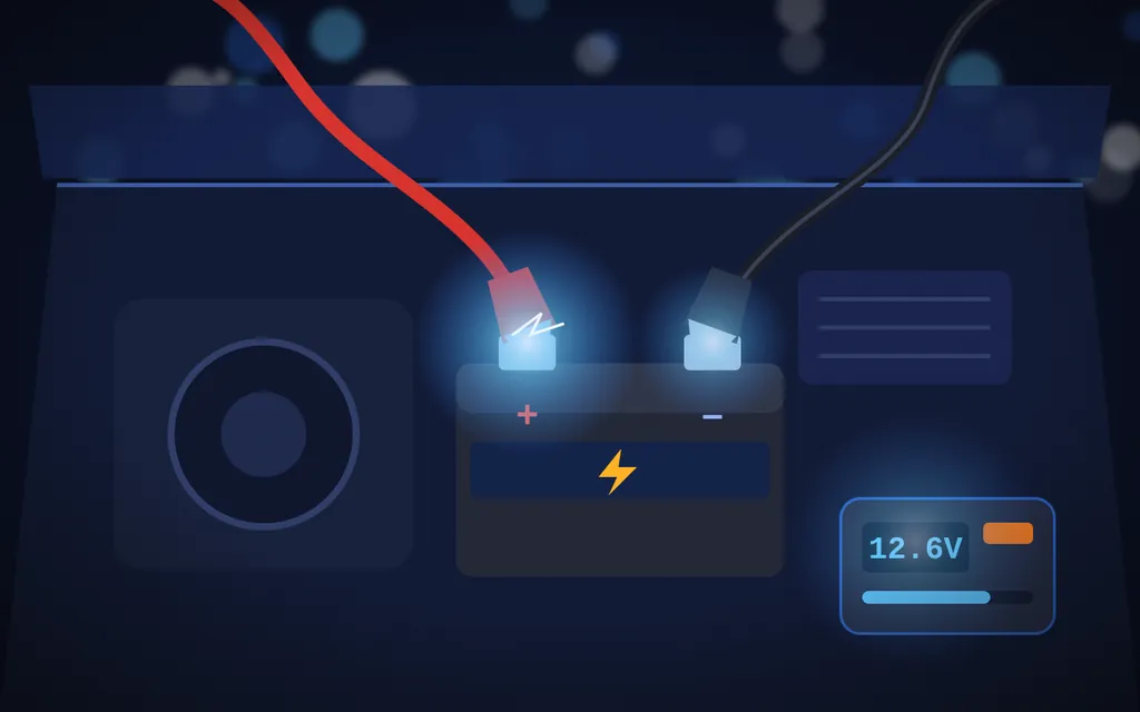 Red and black jumper cable clamps connected to a car battery next to a portable jump starter showing 12.6 volts